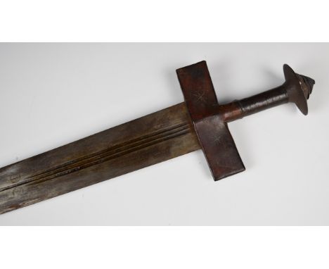 North African Tuareg sword in leather scabbard, L106cm.&nbsp;WE ARE NOT ABLE TO OFFER OUR USUAL POSTAGE SERVICE FOR THIS LOT