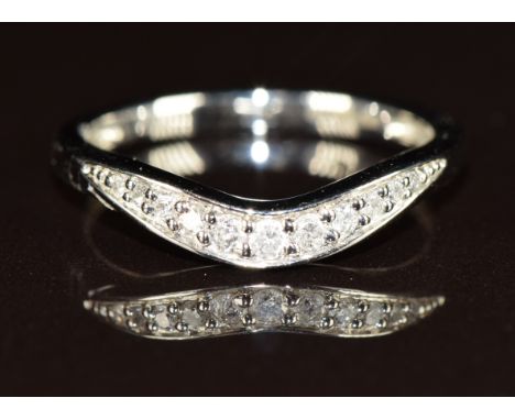 A platinum ring set with eleven diamonds in a curved setting, the total diamond weight approximately 0.15ct, 8g, size M