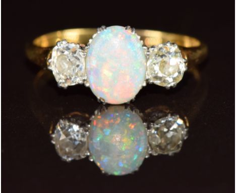 A c1900 18ct gold ring set with an oval opal cabochon and two old cut diamonds each approximately 0.3ct, 2.8g, size Q