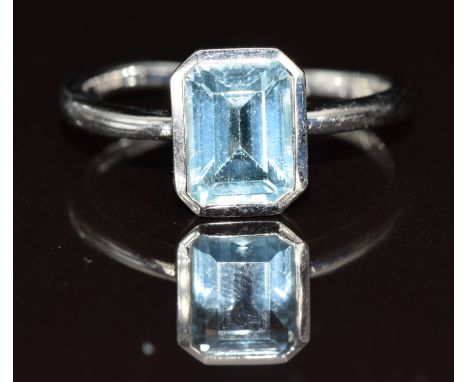 A 9ct white gold ring set with an emerald cut topaz, 2.8g, size N