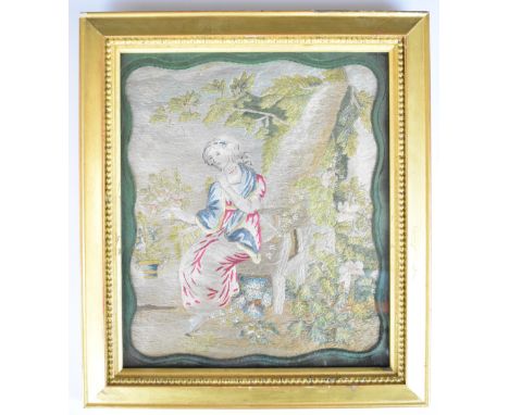 19th century needlework or tapestry picture of a lady on a bench beside a tree in a garden, in period gilt frame, overall siz