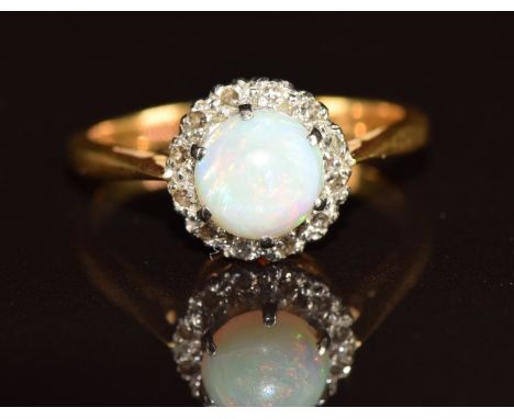 A c1930 18ct gold ring set with an opal cabochon surrounded by diamonds, 3.4g, size L