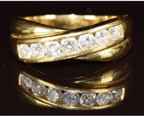An 18ct gold ring set with seven round cut diamonds of approximately 0.08ct to 0.12ct in a cross over setting, 5.7g, size Q