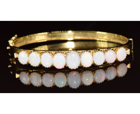 A yellow metal bangle set with nine oval opal cabochons, in antique Searle &amp; Co bangle box, 13.4g, 4.5 x 5.2cm&nbsp;