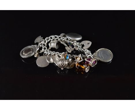 A silver charm bracelet with twenty two silver charms including 'Welsh Football League' fob, locket, St Christopher, bible, s