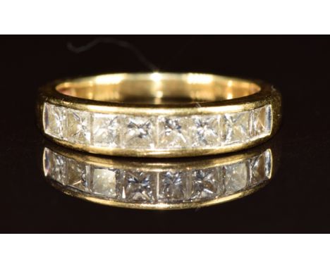 An 18ct gold ring set with eight graduating princess cut diamonds, the centre diamond approximately 0.15ct, 3.6g, size N