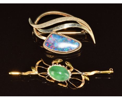 A 10k gold brooch set with a black opal doublet (5.1g, 4cm) and a yellow metal brooch in the form of a crab set with a jadeit