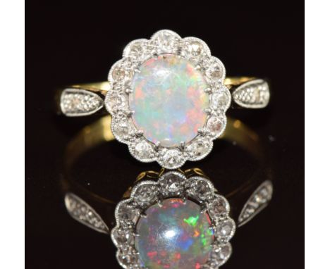 A c1930 18ct gold ring set with an opal cabochon surrounded by diamonds in a platinum setting, 2.8g, size N