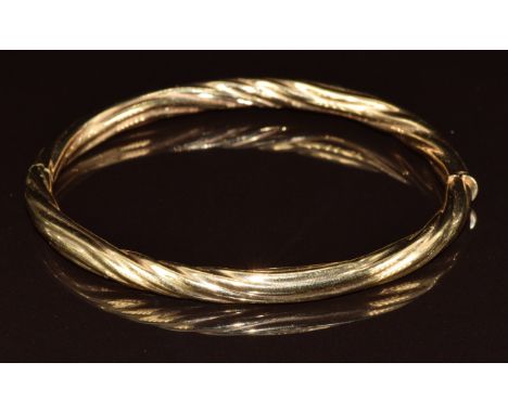 A 9ct gold bangle with textured ripple finish, 12.4g, 6.2 x 5.2cm