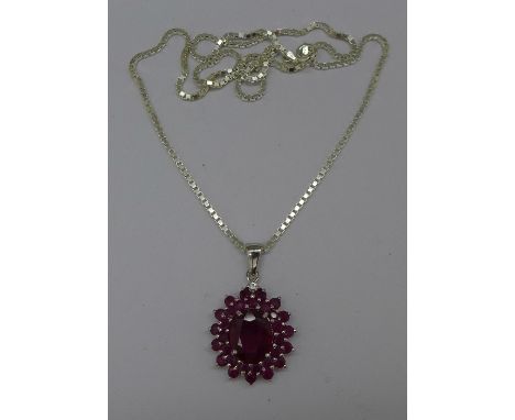A silver and ruby pendant and chain