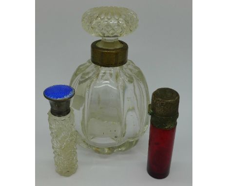 A ruby glass scent, a scent with a silver and enamel top and a silver rimmed bottle, enamel a/f, ruby top a/f