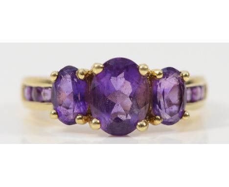 A 9ct gold amethyst three stone ring with amethyst set shoulders, L, 2.6g