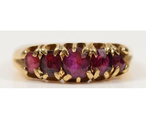An 18ct gold ruby five stone carved claw dress ring, J 1/2, 3.5g
