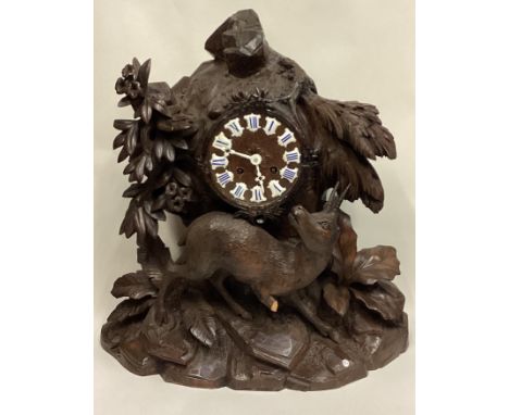 A Continental carved oak mantle clock. Est. £40 - £60.