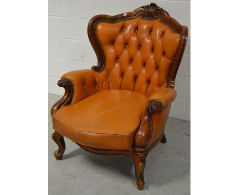 An early 20th century mahogany framed armchair upholstered in tan leather, deep button back on cabriole legs.