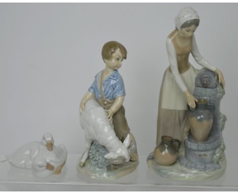 A Nao figure group of a boy calming a ram, approx height 22cm, a Nao figure of a woman by a fountain with amphora, approx hei