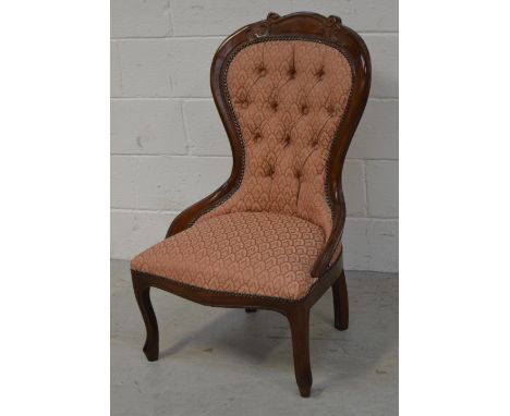 A reproduction button back upholstered low nursing chair.