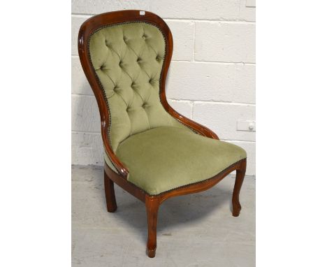 A reproduction mahogany button back nursing chair.