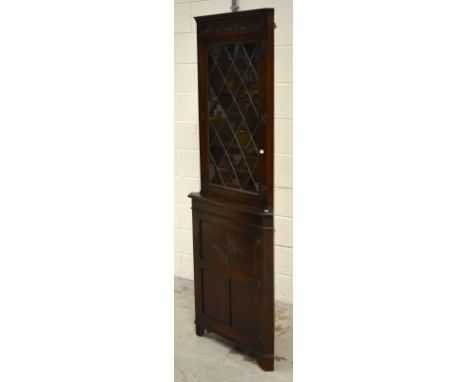 An oak reproduction corner cupboard, glazed door with two interior shelves above a single cupboard door with one interior she