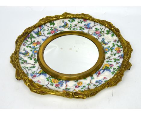 A Crown Devon mirror, a floral ceramic frame within a gilded mount, diameter 38cm.