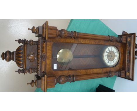 A 19th century Vienna wall clock: mahogany with bracket arch pediment with mask of lady: enamel dial