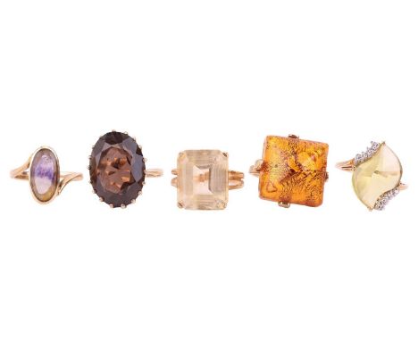 Five rings comprising a lemon quartz cocktail ring, in yellow metal tested as 18ct gold, size Q, a smoky quartz cocktail ring