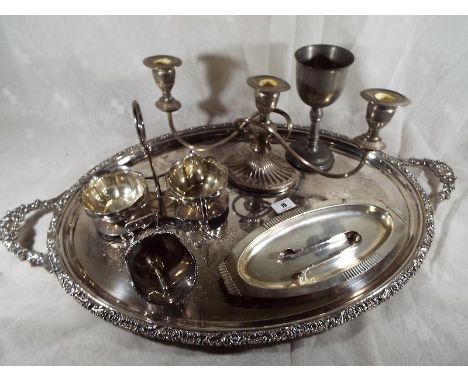A collection of plated ware to include a large twin handled salver, sauce stand, candelabra and other
