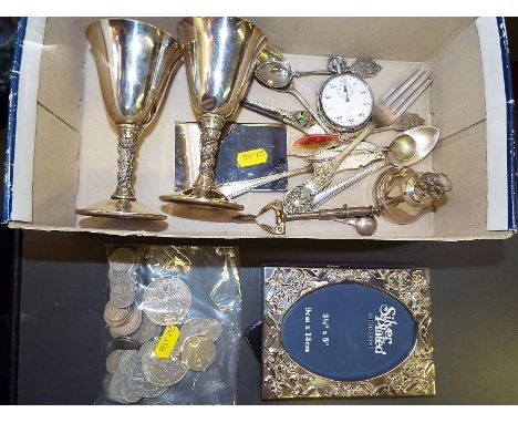 A mixed lot of silver plated ware to include flatware, photograph frame, mechanical sugar tongs, stopwatch, UK and World coin