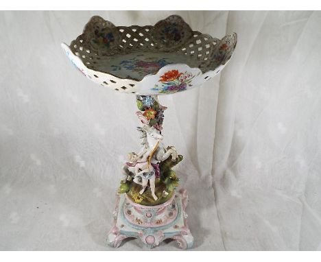 An 18th century comport and stand, the stem encrusted with applied floral decoration with caped woman and horse, over a raise