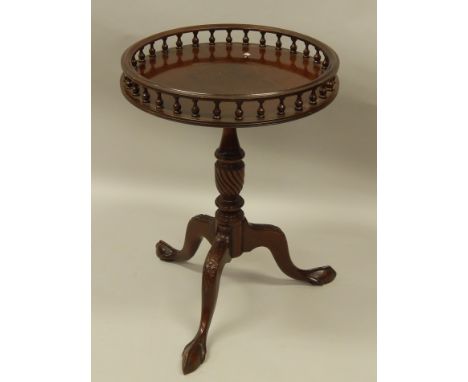 A reproduction mahogany occasional table, on turned column and tripod base.