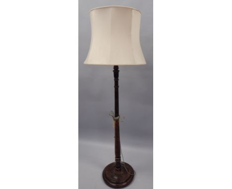 A turned and stained beech standard lamp, on a circular base, with shade. Provenance: Butterfields, Thoresby Park, Nottingham