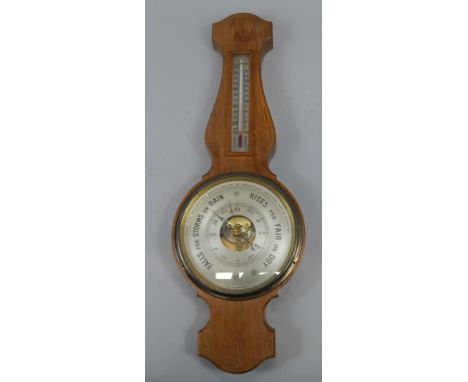 A modern aneroid barometer, in an oak case, with thermometer, 56cm high.