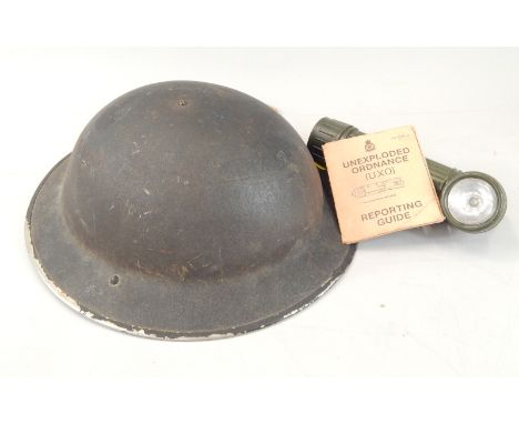 Military items, to include an air warden's helmet, torch and a manual for unexploded ordnances