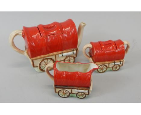 A novelty three piece tea set, each modelled in the form of a Wild West wagon or caravan, to include teapot, milk jug, and co