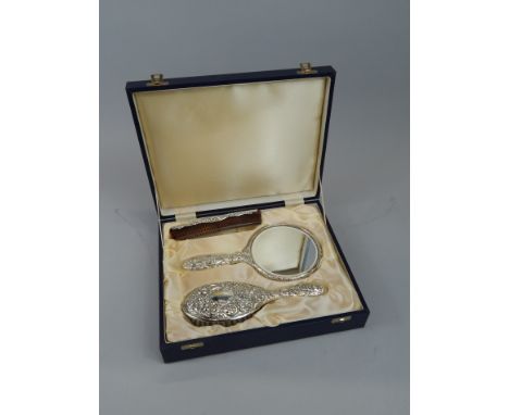 A modern silver dressing table set, comprising hand mirror, hand brush, and a comb with silver mount, in fitted case.