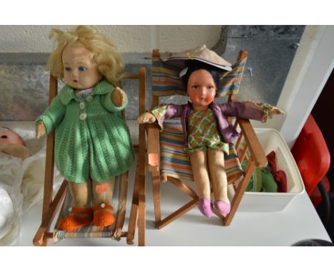 TWO SEATED DOLLS, the first with blonde hair, blue eyes, rosebud mouth, no markings, seated on a deck chair, the second a clo