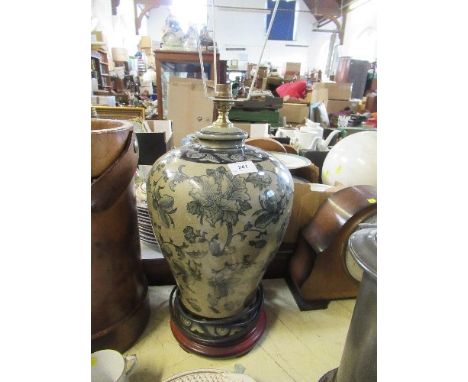 A modern porcelain lamp base, decorated with flowers, on a wooden base