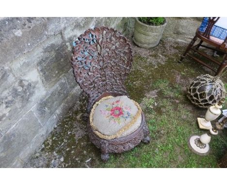 A 19th century Anglo-Indian carved low chair - possibly padouk, with pierced and carved leaf decoration, with circular tapest