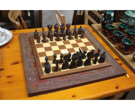 A carved ethnic wooden chess set with two boards