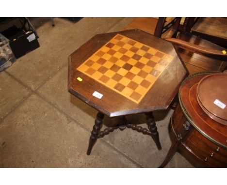 An octagonal topped games table, raised on bobbin turned supports 