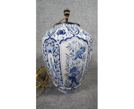 A ceramic bulbous form Majolica blue and white hand painted floral design table lamp with silk wrapped cord. Signed LF to the