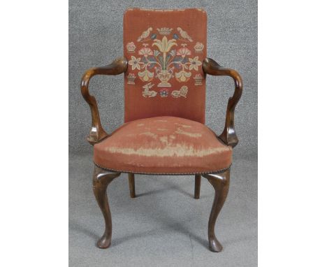 An early Georgian style walnut framed armchair in tapestry upholstery. H.90cm 