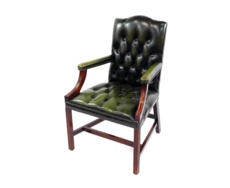 A green leather and mahogany armchair, with button green leather back and overstuffed seat, padded arms, raised on chanelled 