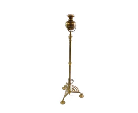 A Victorian brass standard oil lamp, raised on three cast legs, on circular feet, 134cm high.