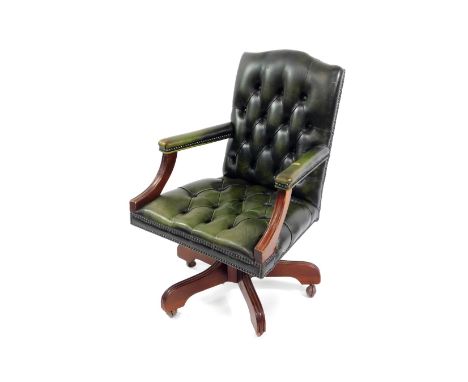 A green leather and mahogany swivel office chair, with button green leather back and overstuffed seat, green leather padded a