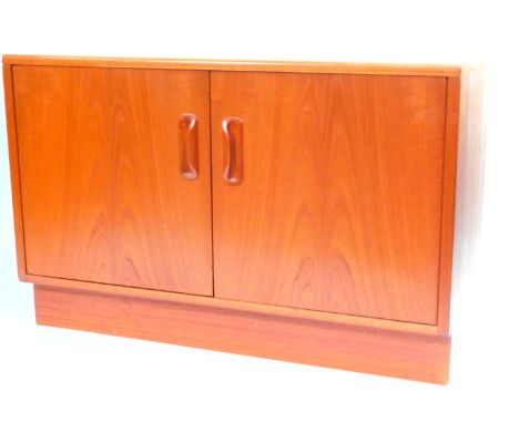 A G-Plan cupboard, with two doors opening to reveal a single shelf, raised on a plinth base, 53.5cm high x 81.5cm wide x 45.5