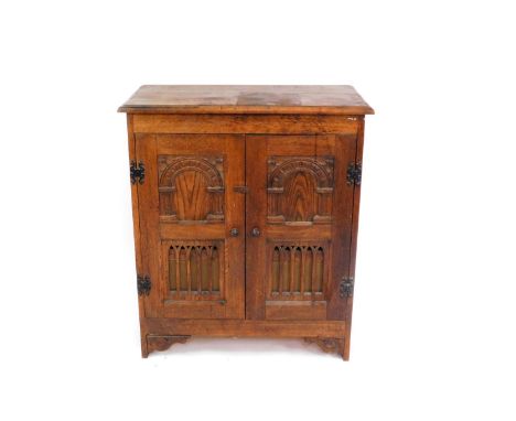 An Elizabethan style oak cased radiogramme with an Empress radio, containing 78rpm and other records, the cabinet with a pair