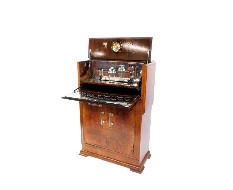 An Art Deco walnut and burr walnut cocktail cabinet, the levered top section opening to reveal a fitted interior with lightin