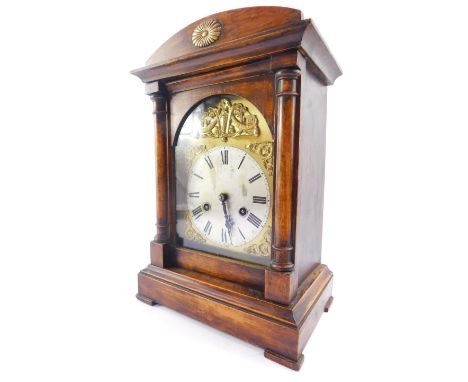 A German early 20thC stained pine mantel clock, brass break arch dial, silvered face bearing Roman numerals, Junghans eight d