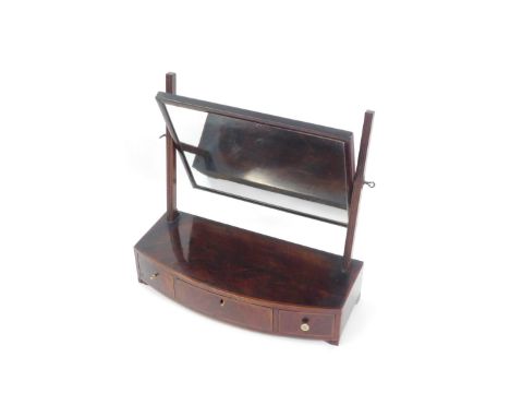 A George III flame mahogany and satinwood cross banded toilet mirror, the rectangular swing frame mirror above a bow fronted 